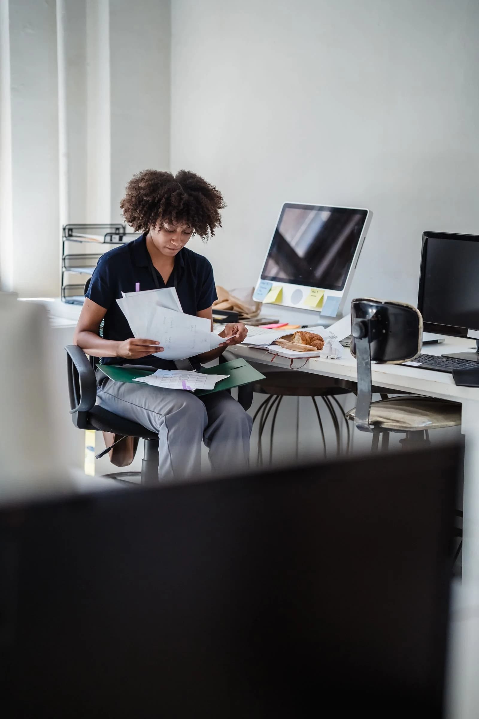 A business owner sorting a backlog of papers in a bright office